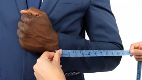 Hands-of-fashion-designer-taking-a-measurement-of-businessman