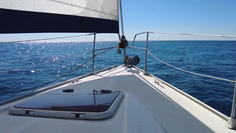 Passenger-on-a-sailboat-waving-at-another-boat-on-a-sunny-day