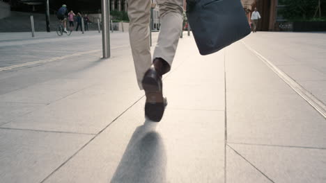 close crop of businessman feet walking in city