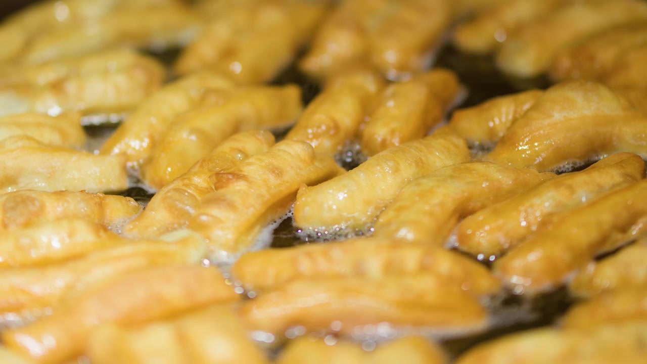 Primo piano dell'impasto tradizionale di patongko che frigge in un wok con olio bollente e frizzante