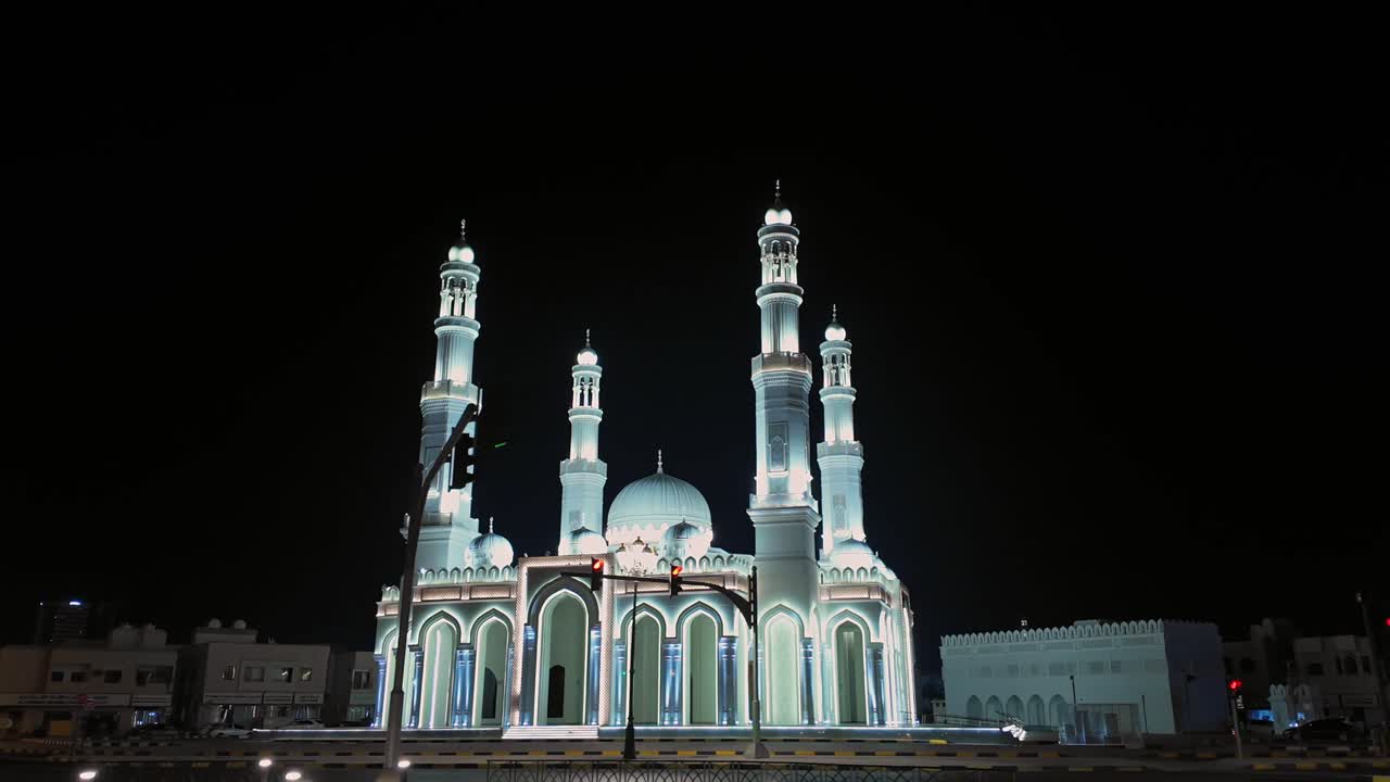 Una vista di una moschea splendidamente illuminata di notte a Sharjah, Emirati Arabi Uniti.