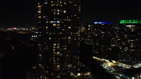 flying downtown toronto city skyscrapers with illuminated buildings windows across the skyline