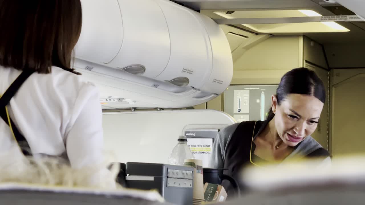 azafata sirviendo a los pasajeros en un avión con una sonrisa