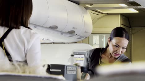 stewardess serving passengers on a plane with a smile