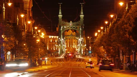day to night sunset time lapse of liberty bridge telephoto, tram traffic, hungary, budapest, 09.09.2022
