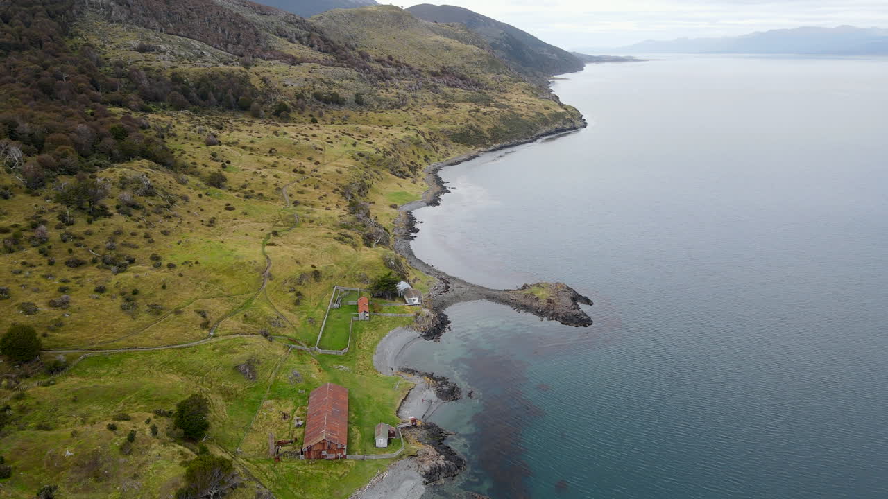 Video di drone in volo in avanti su un fienile lungo la costa oceanica