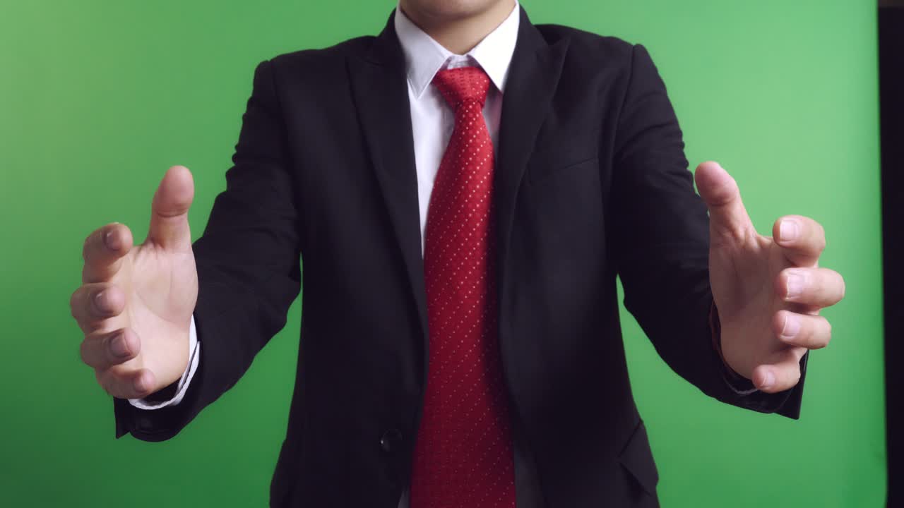 Businessman with open hands on green screen