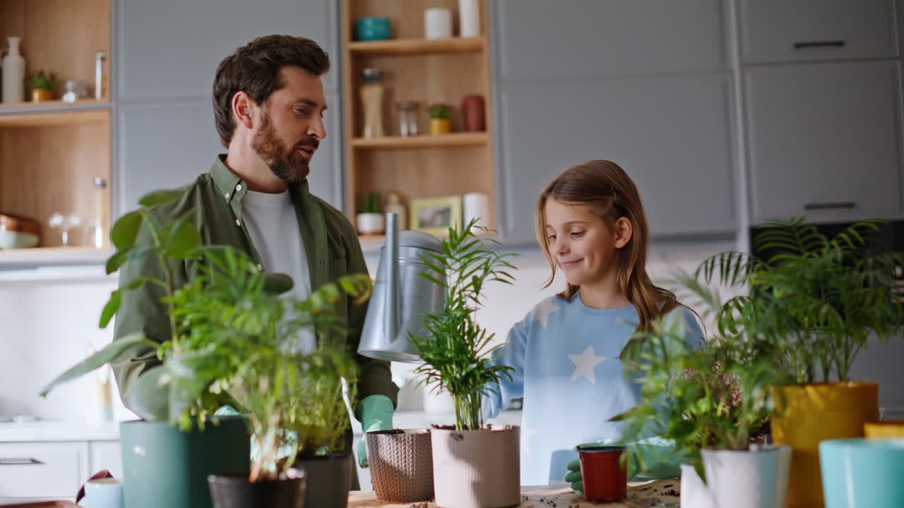 Dad daughter enjoy gardening transplanting green plants in pots together closeup