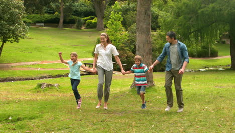 Familia-Feliz-Saltando-En-El-Parque