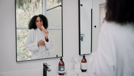 woman singing into hairbrush in bathroom mirror