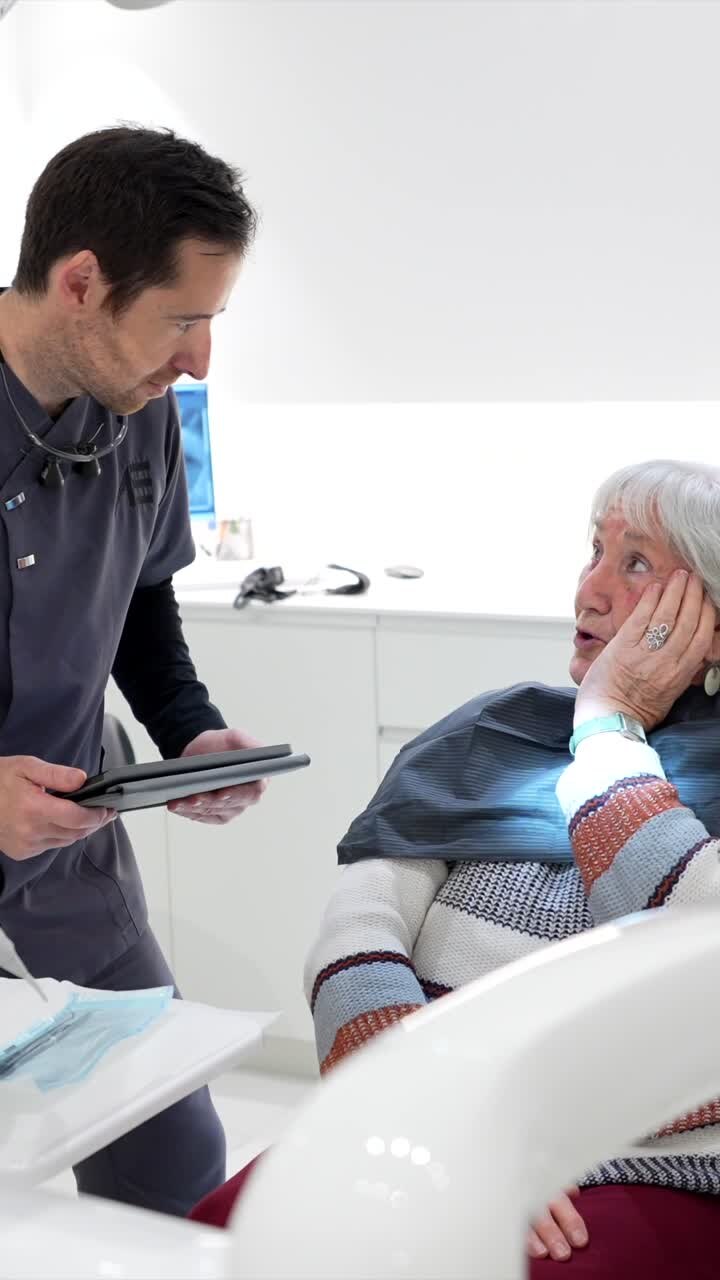 Dentist interacting with elderly patient in dental clinic