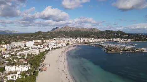 Aerial-View-Of-Port-d'Alcudia-with-Harbor-and-Mountain-in-Background