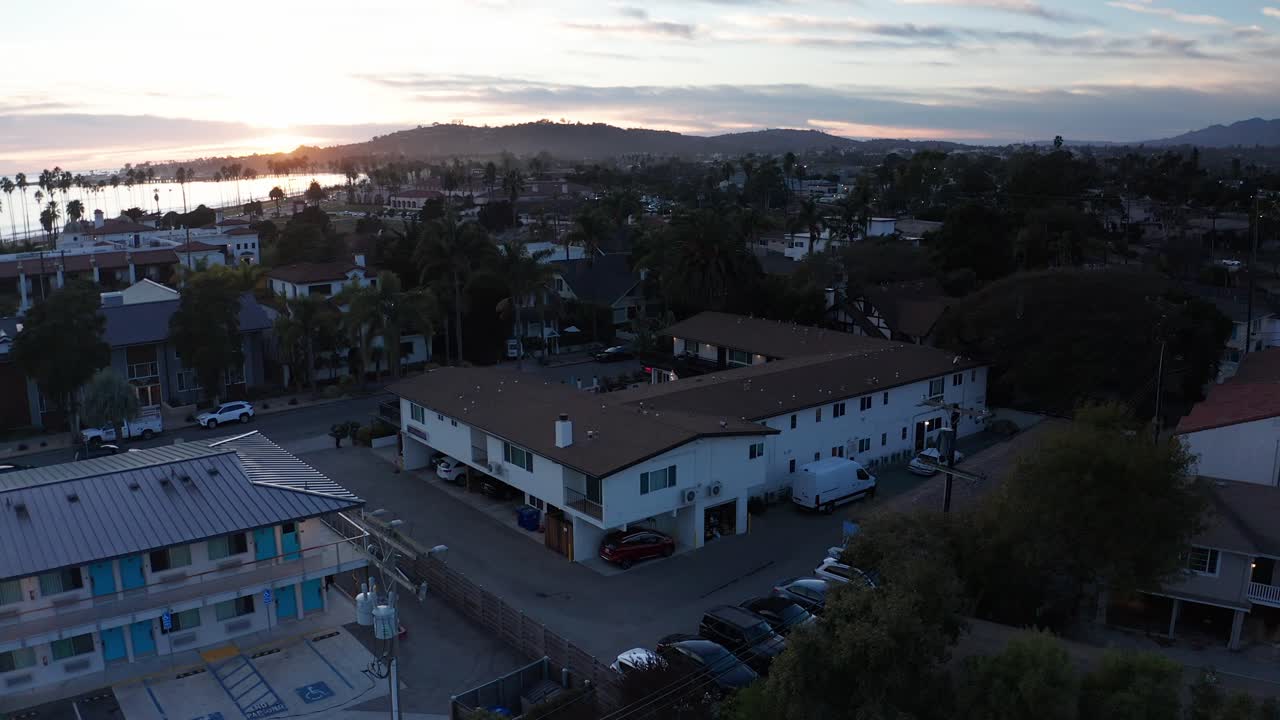 Aerial descending close-up shot of the charming Seaside Inn at sunset in Santa Barbara, California. 4K