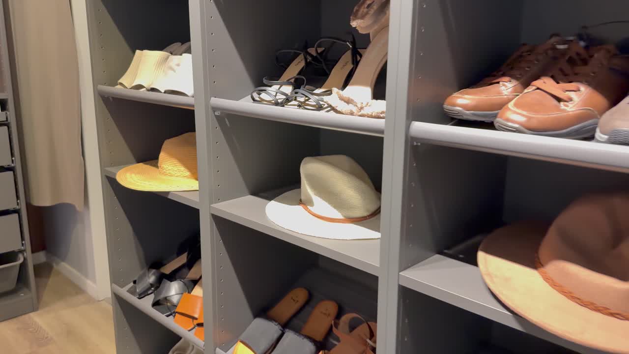 선반 에 끔 히 배열 된 신발 과 모자