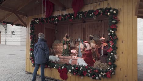 woman visits large nativity scene set up in public square, budapest
