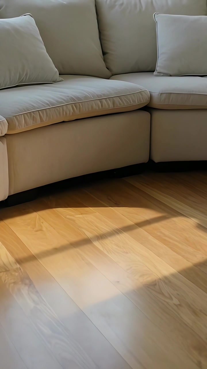 Vertikal video: Vippende, panorerende kamera viser beige sofa i hjemmet med vinduesskygge på trægulv