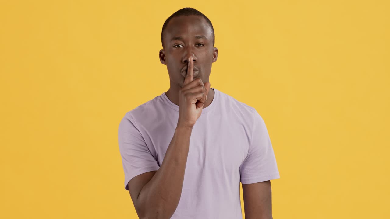 Man with finger on lips, quiet gesture