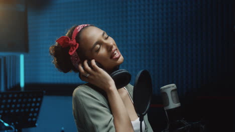 Primer-Plano-De-La-Joven-Y-Hermosa-Cantante-Grabando-Una-Canción-Mientras-Canta-Su-Parte-Solista-En-El-Micrófono-En-El-Estudio-De-Sonido