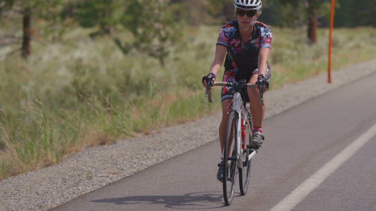 un ciclista recorre un camino rural hacia la cámara 1