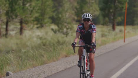 a cyclist rides on a rural road towards the camera 1