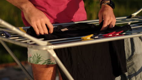 Person-Doing-Laundry-Outdoors-with-Clothes-on-Drying-Rack