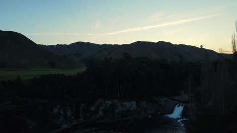 Evening-falls-on-golf-course-with-sunset-and-mountains-in-the-background-in-New-Zealand