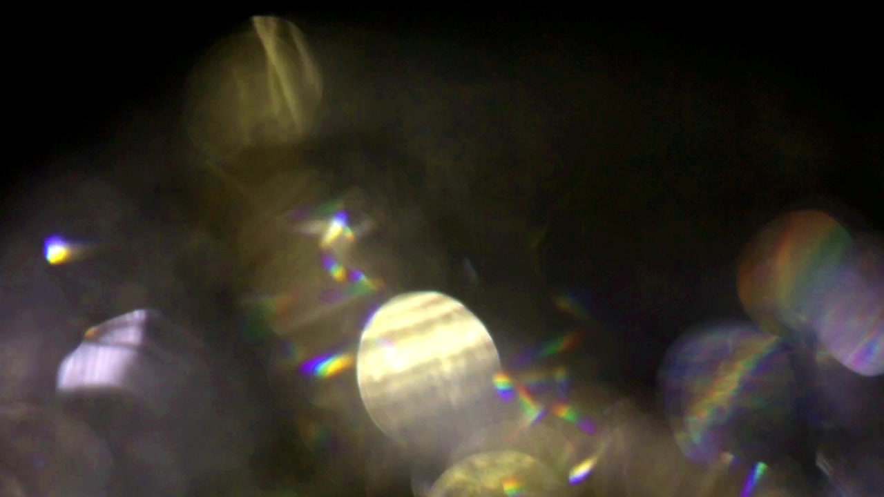 Fughe di luce astratte e sovrapposizioni bokeh su sfondo nero