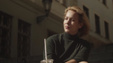 businesswoman enjoying the warm sunlight while drinking coffee