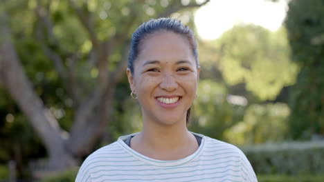 smiling woman outdoors in park, enjoying sunny day and nature