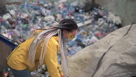 Woman-Worker-In-Yellow-Jacket-And-Transparent-Protecting-Glasses-Sorting-Used-Plastic-Bottles-At-Modern-Recycling-Plant