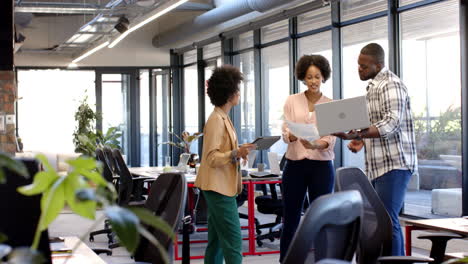 african american business colleagues discuss work with laptop, graphs in office, copy space