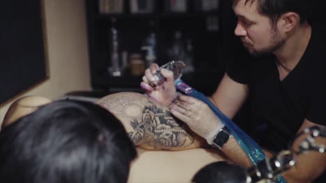 artista del tatuaje trabajando en un diseño de tatuaje