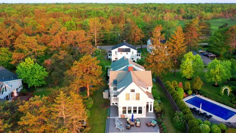 drone shot of a beautiful maine beach cottage. real estate gem with large patio, lush yard, ocean view, and sandy shore. relaxing summer getaway with prime coastal property on the atlantic.