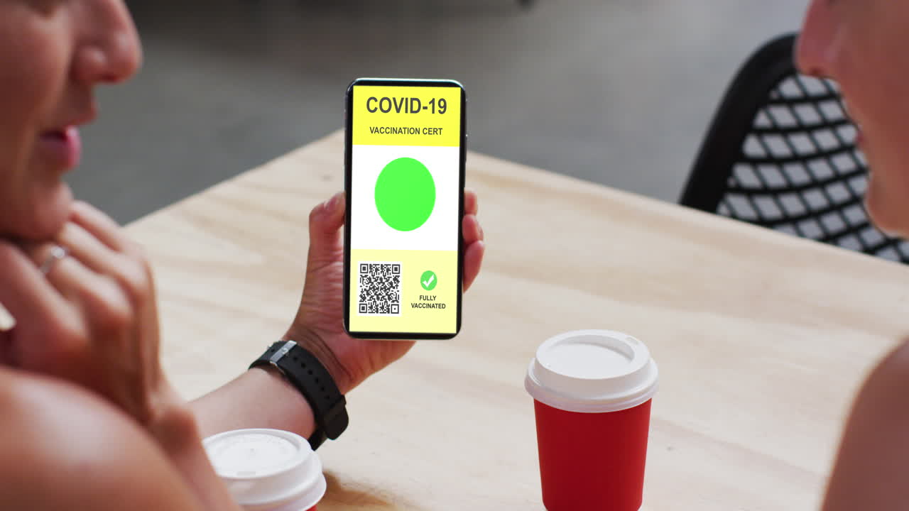hombre en un café mostrando un teléfono inteligente con certificado de vacunación contra la covid y código qr en la pantalla