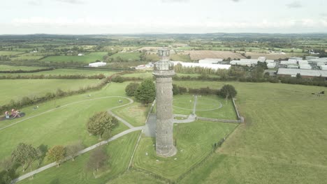 histórica aguja de lloyd en kells, irlanda, rodeada de campos verdes y cielos parcialmente nublados, vista aérea
