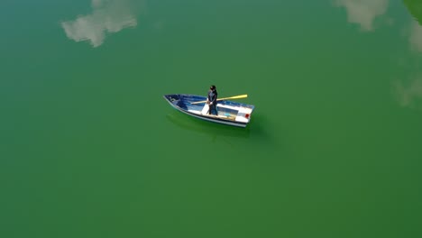 woman on the boat catches a fish on spinning in norway.