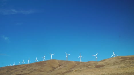 windmills capture nature's power on an exposed wind-swept landscape in the columbia river gorge of washington state