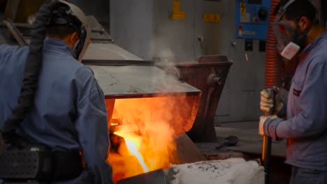 men pouring liquid metal from furnace - hot like fire