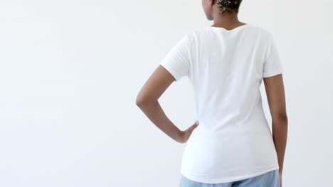 Midsection-of-african-american-woman-wearing-white-t-shirt-with-copy-space-on-white-background