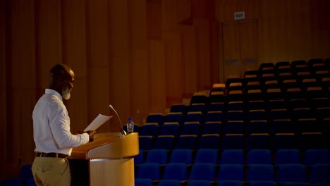 Senior-African-American-businessman-practicing-speech-in-empty-auditorium-4k