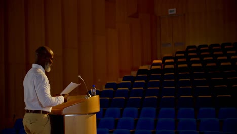 un empresario afroamericano practicando el discurso en un auditorio vacío de 4k.