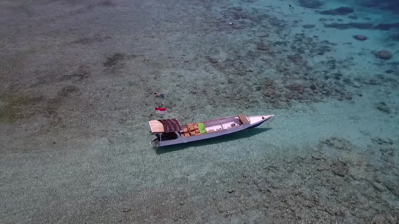 2017년 여름 낮 인도네시아 길리 트라왕안 해변의 드론 영상 청록색 물에 있는 단일 현지 어선 부드러운 공중 전망 비행 필립 마르니츠의 위에서 본 영화 보기