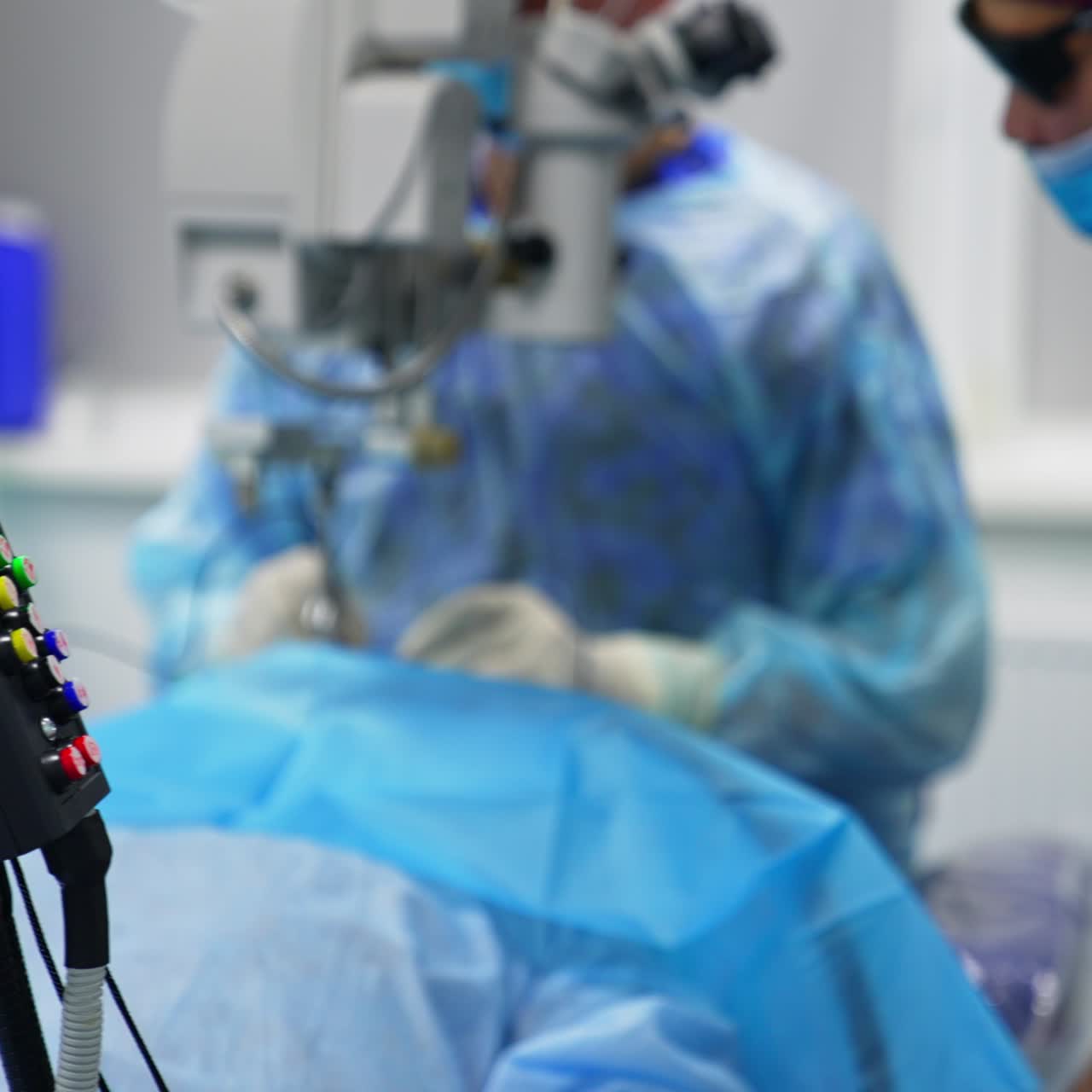 Control panel with colorful buttons and green light. Ophthalmological operation performed at the backdrop