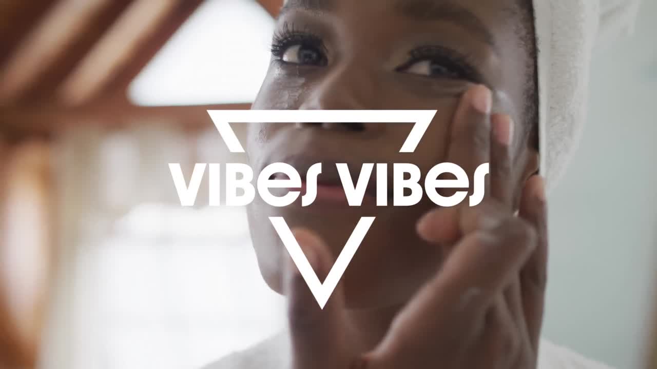 Animation of vibes text over african american woman using cream in bathroom