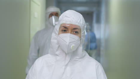 female doctor in protective uniform walking in hospital