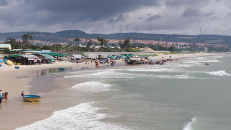 coastal fisherman village in mui ne vietnam, aerial tracking above crowded fish market