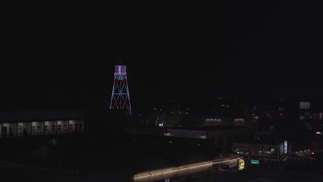 water tower in downtown lit up with candy cane christmas lights