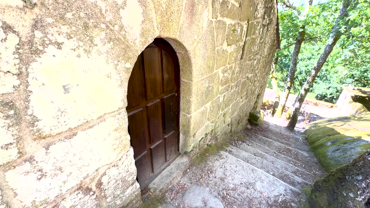 Arched wooden door and stone steps at San Pedro de Rocas in Esgos, Ourense, Galicia, Spain