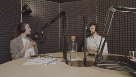 Eine-Elegante-Junge-Frau-Mit-Pferdeschwanz-Und-Ein-Junger-Gutaussehender-Mann-Unterhalten-Sich-In-Einem-Radioaufnahmestudio