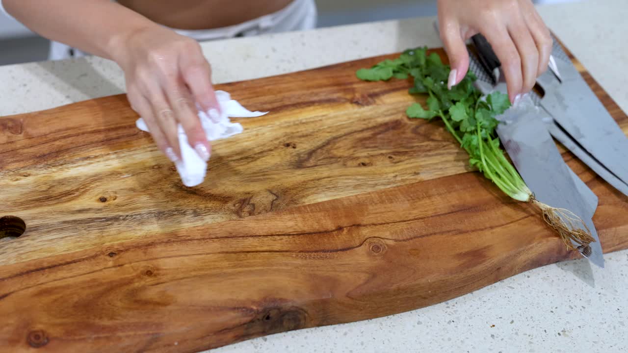 Woman cleaning a wooden chopping board